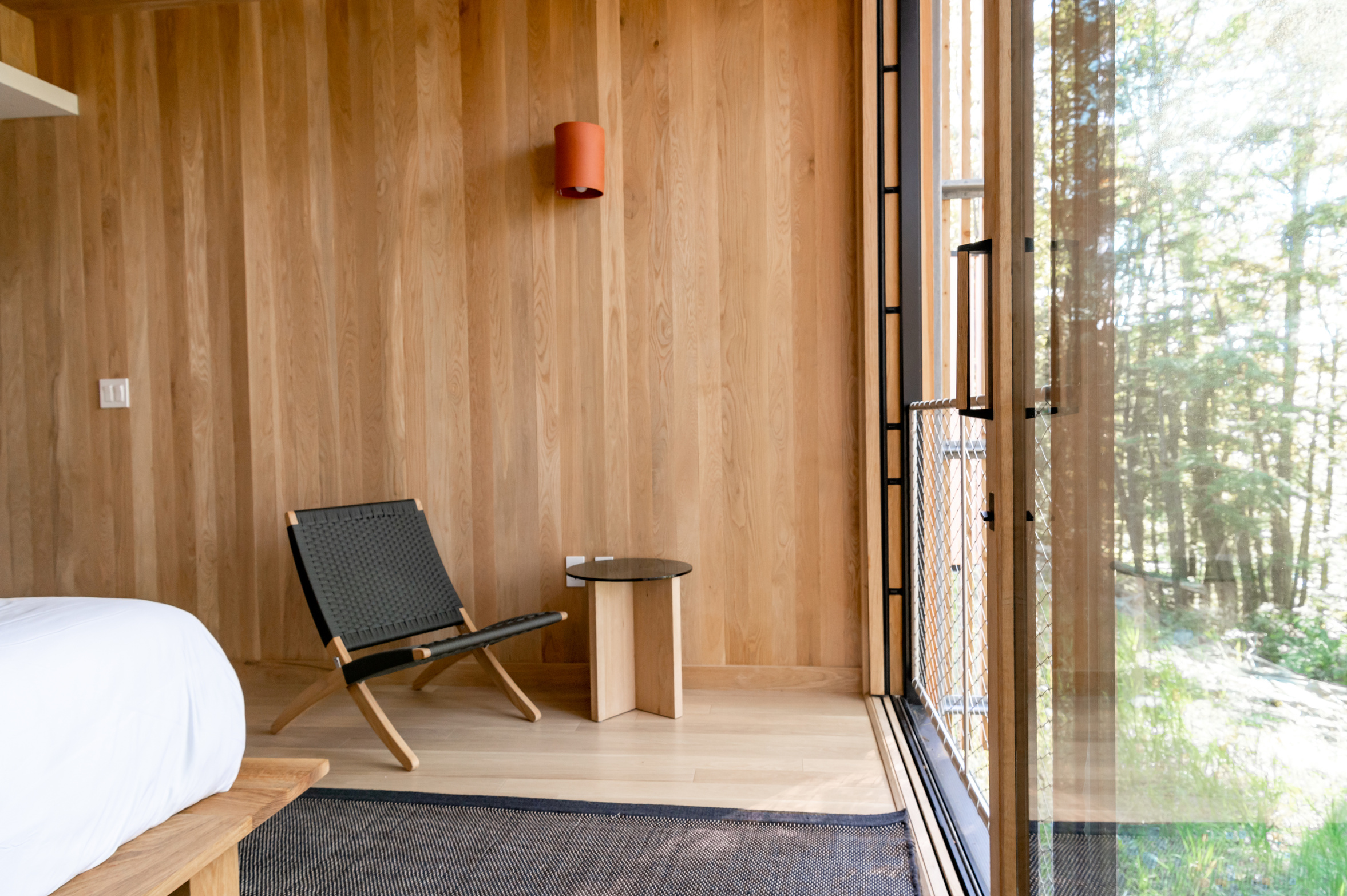 Black and White Chair Beside Brown Wooden Wall